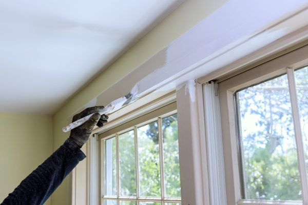 Brush is used to paint window moldings with white paint